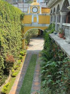 Una pasarela con un reloj en un edificio en Ciudad Vieja Bed & Breakfast Hotel, en Guatemala