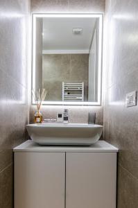 uma casa de banho com um lavatório e um espelho em Schiaparelli 4 em Milão