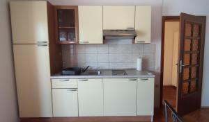 una cocina con armarios blancos y fregadero en Bordon wines, estate with accommodation, en Dekani
