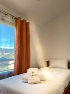 um quarto com 2 camas e toalhas em Gîte le Fouquet em Cilaos