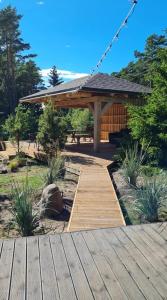 a wooden walkway in a garden with a pavilion at My little happy place in Undva