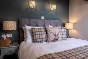 um quarto com uma cama com uma almofada de veado e candeeiros em Sunnyside Guest House em Keswick