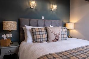 a bedroom with a bed with a deer pillow and lamps at Sunnyside Guest House in Keswick