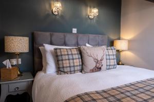 a bedroom with a bed with a deer pillow and lamps at Sunnyside Guest House in Keswick