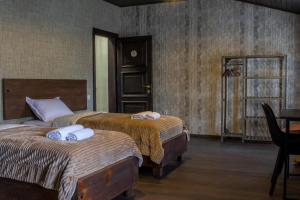 a bedroom with two beds and a table and a window at Hotel Eden in Mestia