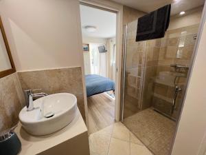 ein Bad mit einem Waschbecken und einer Dusche in der Unterkunft Studio with private car park and air con in Valbonne
