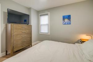 a bedroom with a bed and a dresser with a tv at Washington DC Gem with Fenced Backyard in Washington