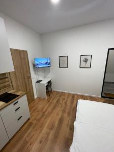 een slaapkamer met een bed, een bureau en een televisie bij Airport Apartment 29 Self Check-In Free parking in Vilnius