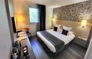 a hotel room with a large bed and a window at Hotel Restaurant Du Parc Saumur Logis Elégance in Saumur