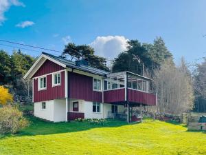una casa roja y blanca en la cima de un campo en 4 person holiday home in HAKENÄSET-By Traum, en Lind