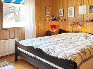1 dormitorio con 1 cama grande y paredes de madera en Holiday home NORRTÄLJE IV, en Norrtälje