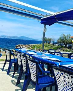 een blauwe tafel met stoelen en uitzicht op de oceaan bij APARTAMENTO L'ESCALA in L'Escala