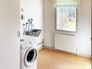 uma lavandaria com uma máquina de lavar roupa e uma janela em Holiday home ASKERSUND em Askersund