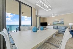 a dining room with a table and chairs and a couch at Phoenix VIII 1406 in Orange Beach