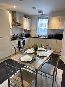 a kitchen with a wooden table and chairs in a kitchen at Relax Inn in Liverpool