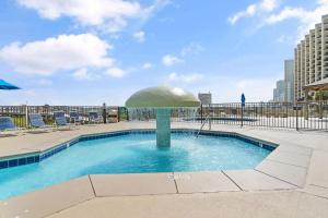 a pool with a umbrella in the middle of it at Phoenix VIII 1406 in Orange Beach