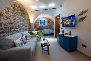 a living room with a couch and a stone wall at U Catoiu in Scilla