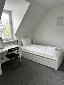 a bedroom with a bed and a desk and a window at Relax Inn in Liverpool