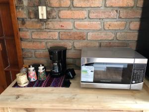 a microwave sitting on a table next to a brick wall at Suite Bellavista Cuenca in Cuenca