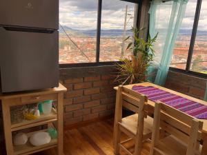 a room with a table and chairs and a window at Suite Bellavista Cuenca in Cuenca