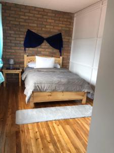 a bedroom with a bed and a brick wall at Suite Bellavista Cuenca in Cuenca