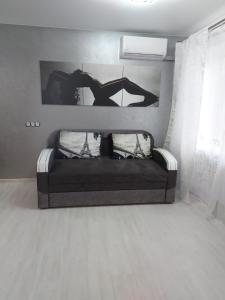 ein schwarzes Sofa in einem Zimmer mit Fenster in der Unterkunft Lux apartment Sadovaya street in Mykolajiw