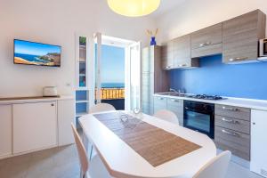 a kitchen with a white table and a dining room at Appartamento Moderno con vista mare in Castelsardo