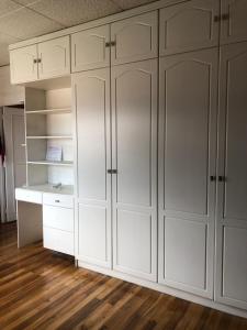 a white closet with white cabinets and a desk at Suite Bellavista Cuenca in Cuenca