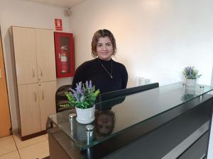 una mujer está de pie detrás de un mostrador con flores en Room 5 Star Miraflores, en Lima