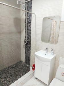 a white bathroom with a shower and a sink at Lux apartment Sadovaya street in Mykolaiv