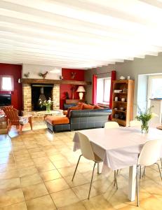een woonkamer met een bank en een tafel en stoelen bij Logement de charme calme assuré in Rieux