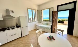 uma cozinha com uma mesa e uma cozinha com vista para o oceano em Il Frantoio di Avola em Avola