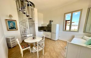 a kitchen and a living room with a table and a refrigerator at Il Frantoio di Avola in Avola