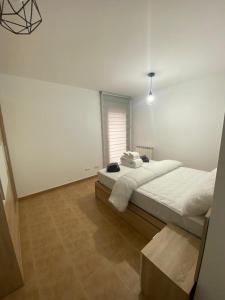 Casa Alma في Alceda: غرفة نوم بيضاء مع سرير كبير ونافذة