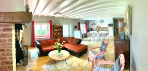 a living room with a couch and a table at Logement de charme calme assuré in Rieux