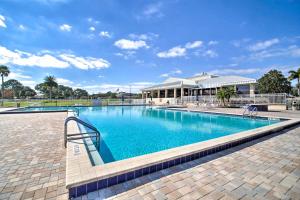 a large swimming pool with a building in the background at Orlando Vacation Rental with Yard and Pool Access in Orlando