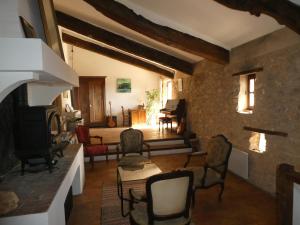 a living room with chairs and a fireplace at Le Jas des aiguiers in Saint-Saturnin-dʼApt