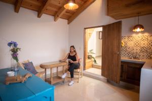 a woman sitting at a table in a room at Hotel Molino del Cerrillo in San Cristóbal de Las Casas