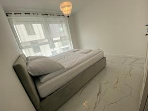 Ce lit se trouve dans un dortoir blanc doté d'une fenêtre. dans l'établissement Seaside Apartment, à Gdańsk