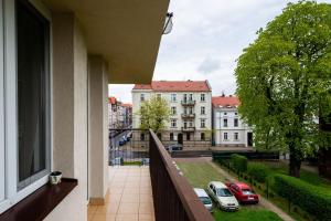 uma varanda com vista para edifícios e carros em Apartament Family - darmowy Parking, blisko centrum - by Kairos Apartments em Gliwice