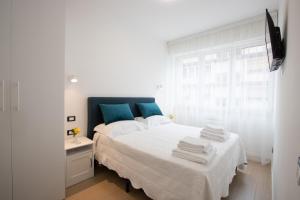 una camera da letto bianca e blu con un letto e una finestra di BB Elite Berchet a Padova