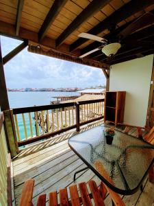 un patio con una mesa de cristal y sillas en una terraza en Aqua Lounge Bar & Hostal en Bocas Town