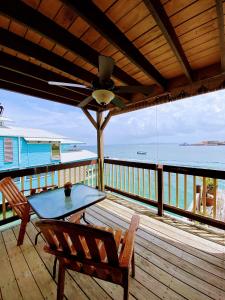 einen Tisch und Stühle auf einer Terrasse mit Meerblick in der Unterkunft Aqua Lounge Bar & Hostal in Bocas del Toro