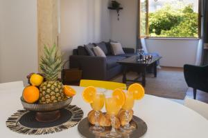 a table with a bowl of fruit and wine glasses at Holiday house VIDA in Biograd na Moru