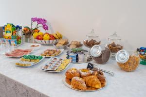 una mesa cubierta con platos de bollería y otros alimentos en BB Elite Berchet en Padova