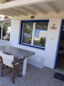 una mesa y una silla frente a una casa en Naxian Sofias garden en Naxos
