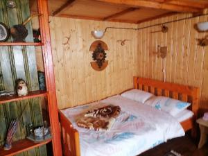 - une chambre avec un lit dans une pièce en bois dans l'établissement Cabana nea Nicu, à Bălceşti