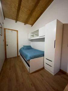 małą sypialnię z łóżkiem i szafą w obiekcie Cabaña río Calle Calle w mieście Valdivia
