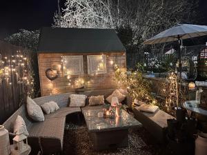 a outdoor couch with lights on a brick wall at The Coorie Inn @ Portobello, Edinburgh’s Seaside. in Edinburgh