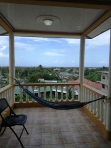 a hammock on the balcony of a house at Pryme Paradise in Carnbee Village